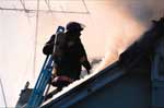 Firefighter on roof of burning structure