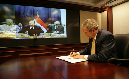 President George W. Bush is joined by Iraq's Prime Minister Nouri al-Maliki, center, via video teleconference Monday, Nov. 26, 2007, in signing the U.S.-Iraq Declaration of Principles for Friendship and Cooperation. The declaration is a shared statement of intent that establishes common principles to frame the future relationship between the two countries. White House photo by Eric Draper