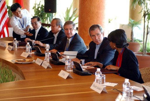 President George W. Bush speaks with National Security Advisor Condoleezza Rice at the start of the group meeting with ASEAN leaders 10th APEC leaders meeting in Los Cabos, Mexico, Saturday, Oct. 26, 2002. Also pictured seated from left are His Majesty Sultan Haji Hassanal Bolkiah Mu'Izzaddin Waddaulah and Pehin Dato Lim Jock Seng both of Brunei and Chief of Staff Andy Card. 