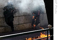 Flames engulf a policeman from a petrol bomb thrown by rioters outside parliament in Athens, 18 Dec 2008