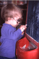 Photo of child with vision impairment drawing on an easel