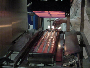 Methane-fired panel which creates a flux gradient for flame spread test of extruded flame retardant polymer sample rods.