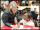 Secretary Spellings talks with a student at Martin Luther King, Jr. Elementary School in Washington, D.C.  The Secretary and First Lady Laura Bush taught a first grade science class together at the school to honor the tenth anniversary of Teach For America Week.