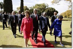Presidents Bush and Mbeki walk together with Mrs. Bush and Mrs. Mbeki after speaking to the media at the Guest House in Pretoria, South Africa, Wednesday, July 9, 2003.  White House photo by Paul Morse