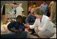 Laura Bush visits with a young boy displaced by Hurricane Katrina in the Cajundome at the University of Louisiana in Lafayette, La., Friday, Sept. 2, 2005. White House photo by Krisanne Johnson