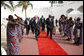 President George W. Bush, walking with Ghana President John Agyekum Kufuor, reaches out to shake hands with a ceremonial greeter on his arrival to Osu Castle, Wednesday, Feb. 20, 2008 in Accra, Ghana. White House photo by Eric Draper