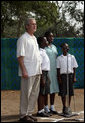 President George W. Bush stands at home plate with 3 members of the Ghana International School choir as they sing the Ghanaian National Anthem Wednesday, Feb. 20, 2008, at a tee ball game at the Ghana International School in Accra, Ghana. White House photo by Eric Draper