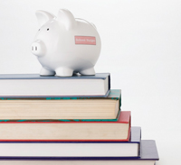 Photo of piggy bank sitting on a stack of books
