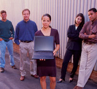 photo of 4 professionals holding a laptop computer