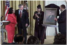 Proclaiming a holiday in honor of Martin Luther King, Jr., President George W. Bush receives a portrait of the civil rights leader from his wife and children in the East Room Jan. 21, 2002. Photographed from left to right are Coretta Scott King, the President, Rev. Bernice King and Martin Luther King III. White House photo by Tina Hager