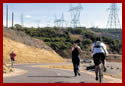 Two bicyclists and a runner along the of the Sacramento Rail Trail