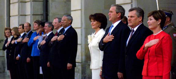 President George W. Bush and First Lady Laura Bush and the American delegation during the playing the American national anthem with the president of Poland Aleksander Kwasniewski and Mrs. Kwasniewski during an arrival ceremony at the Polish Presidential Palace