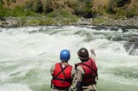 Photo of two kayakers scouting "Clavey" rapids from the bank of the Tuolumne River