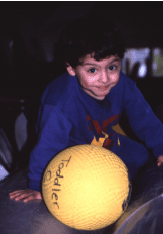 niño jugando con pelota terapéutica
