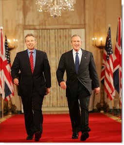 President George W. Bush and Prime Minister Tony Blair of Great Britain, walk through Cross Hall en route to the East Room Thursday night, May 25, 2006, for a joint press availability during which the President said of Iraq's new government, "The United States and Great Britain will work together to help this new democracy succeed." White House photo by Shealah Craighead