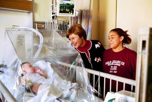 Laura Bush visits with 4-month-old Devon Garner and his mother Tracy Garner at the Children's National Medical Center in Washington, D.C., Friday, Dec. 12, 2003. Mrs. Bush attended the hospital's annual Christmas program. White House photo by Susan Sterner
