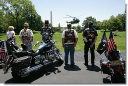 Members of the motorcycle group Rolling Thunder watch President George W. Bush and First Lady Laura Bush land on the South Lawn of the White House from a visit to Camp David. White House photo by Chris Greenberg