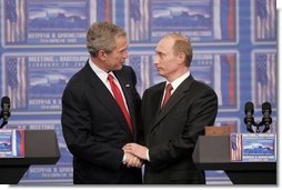President George W. Bush and Russian President Vladimir Putin clasp hands after a joint news conference Thursday, Feb. 24, 2005, in Bratislava, Slovakia. Said President Bush, "I applaud President Putin for dealing with a country that is in transformation," adding, "It's been hard work."  White House photo by Paul Morse