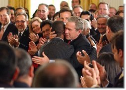 President George W. Bush embraces Brazilian Musician Alexandre Pires after his performance during the Celebration of Hispanic Heritage Month in the East Room, Thursday, Oct 2, 2003.  White House photo by Tina Hager