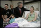 President George W. Bush congratulates Army Specialist Sue Downes after presenting the Iowa City, Iowa soldier with a Purple Heart Friday, Dec. 22, 2006, at the Walter Reed Army Medical Center where she is recovering from injuries suffered in Operation Iraqi Freedom. Joining in the presentation is Pvt. Downes' husband, Gabriel, their son Austin and daughter Alexis, and mother, Faye Partin. White House photo by Eric Draper