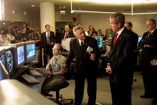 President George W. Bush listens to Hermann Grunder, Director of the Argonne National Laboratory, during a tour of the research facilities with Homeland Security Director Tom Ridge, Secretary of Energy Spencer Abraham and Speaker of the House of Representatives Dennis Hastert, R-IL., in Argonne, IL., July 22. Sponsored by the Dept. of Energy and operated by the University of Chicago, the laboratory is combating terrorism through innovative projects such as detectors for neutrons, biological and chemical agents and developing an emergency response system that coordinates various technologies. White House photo by Paul Morse.