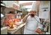 Breaking for a call, Pastry Chef Roland Mesnier prepares dessert, a mango and coconut ice cream dome with peaches, for the state dinner honoring Mexican President Fox, September 5, 2001.