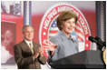 President George W. Bush, background, applauds as Mrs. Bush offers her welcoming remarks, Thursday, Oct. 27, 2005 at Howard University in Washington, at the White House Conference on Helping America's Youth. 