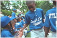 Players congratulate each other in the dugout during the second Tee Ball game on the South Lawn on Sunday, June 3, 2001.