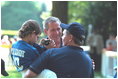Greeting the players and coaches, President Bush makes new friends while hosting the third tee-ball game at his home during the third Tee Ball game on the South Lawn on Sunday, July 15, 2001.