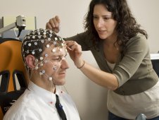 Researcher places probes on test subject's head.