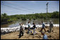 President George W. Bush tours Streb Construction Company in Iowa City, Iowa Thursday, June 19, 2008, as sandbags hold back the flooding Iowa River waters. White House photo by Eric Draper