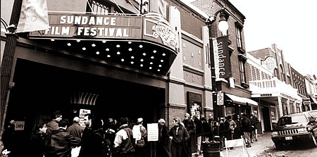 People line up for tickets under the marquee of a theater which reads sundance Film Festival