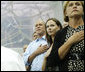 President George W. Bush, daughter Barbara Bush and Mrs. Doro Koch, the President's sister, stand for the playing of the U.S. national anthem Sunday, Aug. 10, 2008, during the medal ceremony honoring gold-medalist Michael Phelps. The U.S. Olympian won his first event, the 400-meter Individual Medley, in a record time of 4:3.84. White House photo by Eric Draper