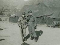 Two buddies standing in front of tents