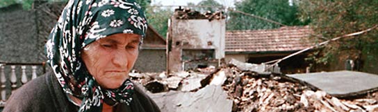 A Chechen woman stands in the ruins of her home in the village of Alleroy. August 2001. (AP Photo/Musa Sadulayev)