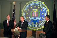 President Bush addresses the media during a tour of FBI headquarters with director Robert Mueller, left, and Attorney General John Ashcroft Sept. 25. White House photo by Paul Morse.