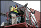 President George W. Bush sits inside the cab of a stacker as its operator, Frederick Bishop, looks on Tuesday, March 18, 2008, during a tour of Coastal Maritime Stevedoring, LLC at the Blount Island Marine Terminal in Jacksonville, Fla. White House photo by Chris Greenberg