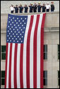 A Marine Band trumpeter plays Taps while first responders and officials salute a flag that hangs on the side of the Pentagon Thursday, Sept. 11, 2008, during the dedication of the 9/11 Pentagon Memorial at the Pentagon in Arlington, Va. White House photo by Eric Draper