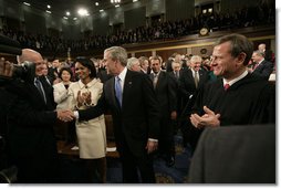 President George W. Bush shakes the hand of Secretary of Treasury Henry Paulson as he arrives on the House floor at the U.S. Capitol Monday, Jan. 28, 2008, to deliver his 2008 State of the Union address. Looking on are Secretary of State Condoleezza Rice and U.S. Supreme Court Chief Justice John Roberts. White House photo by Eric Draper