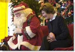Laura Bush talks with children from New Orleans neighborhoods as she sits with Santa Claus, Monday Dec. 12, 2005 at the Celebration Church in Metairie, La., during a Toys for Tots event.  White House photo by Shealah Craighead