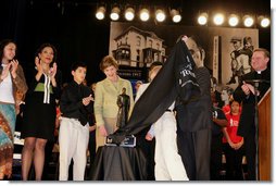 Mrs. Laura Bush flanked by students and Family teachers is presented the Father Flanagan Award during a visit to the Father Flanagan’s Girls & Boys Town in Omaha, NE, Monday, April 3, 2006. White House photo by Shealah Craighead