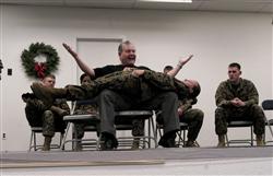 Comedian Ken Whitener demonstrates the power of hypnosis by having Lance Cpl. Jessica Perry, MarForPac combat lithographer, make her body straight as a board and strong enough for him to stand on under hypnosis during the 2008 Holiday Fun Safety Stand Down Dec. 17.