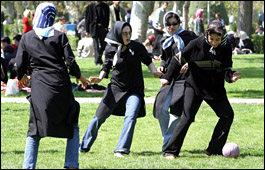 Young Iranian girls play soccer in a park in Tehran.