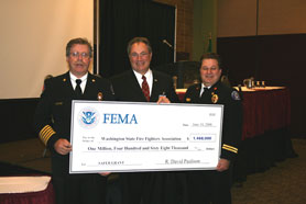 U.S. Fire Administrator Greg Cade (center) presents a $1,468,000 SAFER grant to Washington State Fire Fighters Association