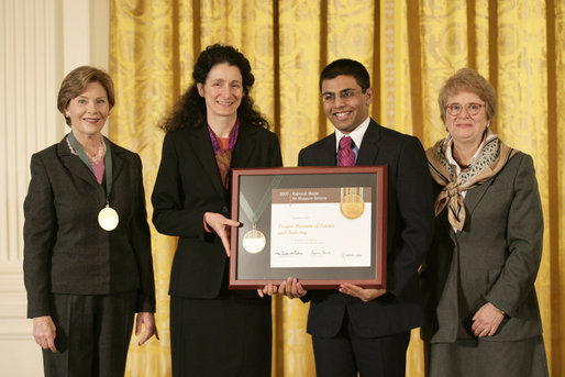 Mrs. Laura Bush along with Dr. Anne Radice, the Director of the Institute of Museum and Library Services, right, presents a 2007 National Awards for Museum and Library Services awards to both Nancy Stueber, Director, and Priyam Shah, Community Representative of the Oregon Museum of Science & Industry, Portland, OR, during a ceremony in the East Room at the White House Monday, January 14, 2008. "Regular visitors to OMSI can touch a tornado, uncover a fossil, experience an earthquake, visit the Northwest's largest planetarium, explore a Navy submarine, or just experiment on their own in one of eight hands-on labs." Mrs. Bush said of the Oregon Museum of Science & Industry during her remarks. White House photo by Shealah Craighead