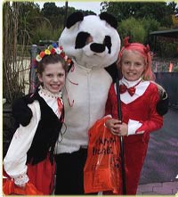 two costumed girls with someone in a panda costume