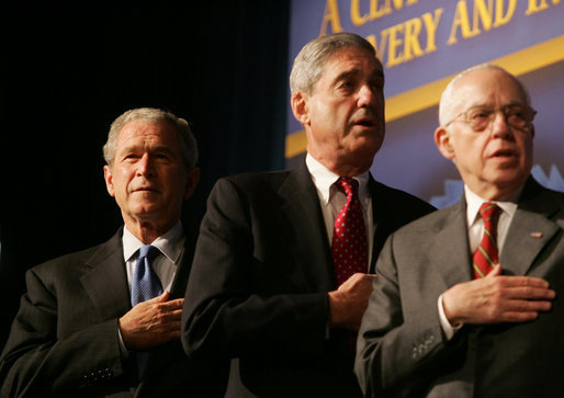 President George W. Bush joins FBI Director Robert Mueller and U.S. Attorney General Michael Mukasey during the playing of the national anthem Thursday, Oct. 30, 2008, at the graduation ceremony for FBI special agents in Quantico, Va. White House photo by Joyce N. Boghosian