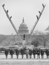Photo of firetrucks forming a 'V' with their ladders in front of the Capitol Building.