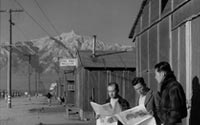 Internees reading newspapers, Manzanar Relocation Center