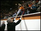 President George W. Bush reaches up to students at Virginia Tech while attending a Convocation Tuesday, April 17, 2007, honoring those involved with Monday's shootings. Thirty-three people, including the gunman, were killed during the country's deadliest shooting that occurred on the campus of the Blacksburg, Va. campus. White House photo by Eric Draper